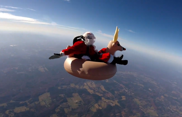 Papai Noel saltando de paraquedas com rena
