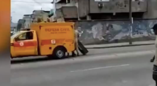 Carro da Defesa Civil deixa gaveta de transporte de corpos cair na rua