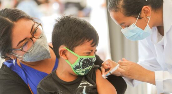 Criança se vacinando vacina