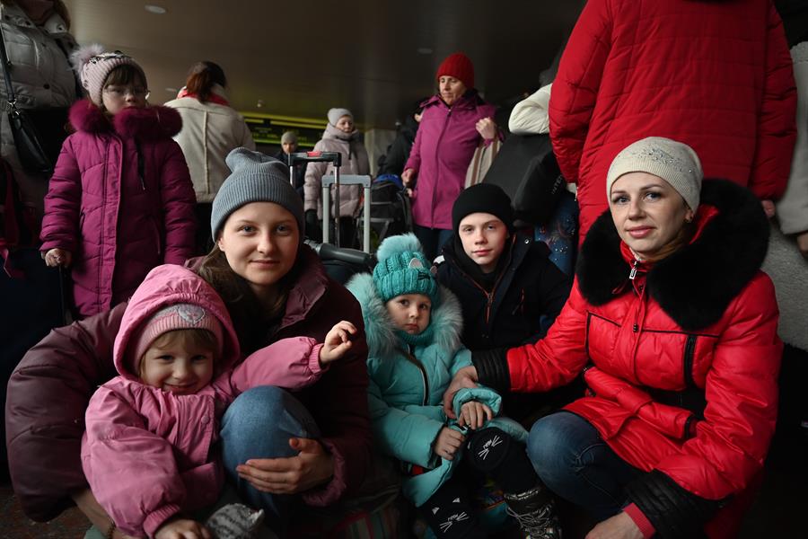 Duas mulheres e seus filhos esperam trem em Kiev