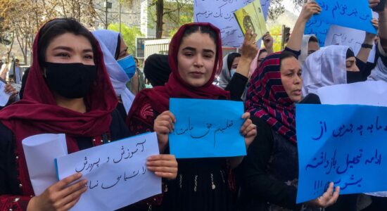 Docentes seguram cartazes durante um protesto no Afeganistão