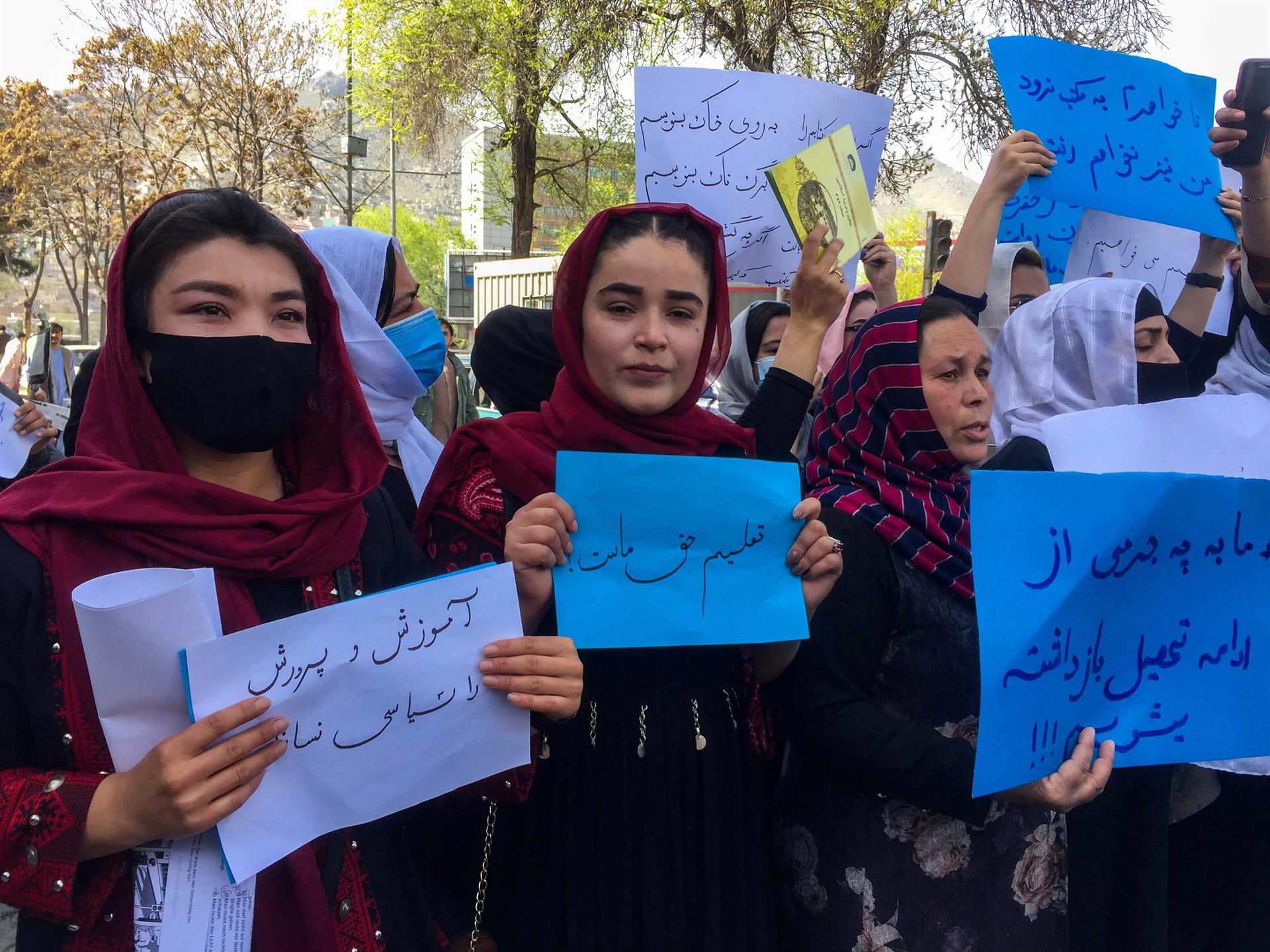Docentes seguram cartazes durante um protesto no Afeganistão