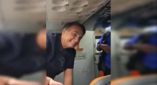Bolsonaro sorri para passageiros no avião